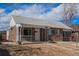 Charming brick home featuring a covered porch and well-maintained landscaping at 865 S Dale Ct, Denver, CO 80219