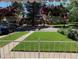 Charming front yard featuring a healthy lawn, mature trees and decorative hanging flower baskets at 865 S Dale Ct, Denver, CO 80219