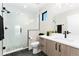 Modern bathroom featuring a glass shower with marble tile, black fixtures and a wood vanity at 1385 N King St, Denver, CO 80204