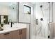 Close-up on a modern bathroom boasting a glass enclosed shower with a marble surround and a floating vanity at 1385 N King St, Denver, CO 80204