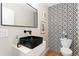Chic powder room with a black geometric patterned wall, vessel sink, and modern fixtures at 1385 N King St, Denver, CO 80204