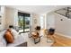 Bright living room featuring hardwood floors, neutral decor, and a large window overlooking the front yard at 1385 N King St, Denver, CO 80204