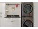 Modern laundry room with stacked LG washer and dryer, and a granite countertop at 2209 Green Oaks Ln, Greenwood Village, CO 80121