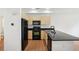 Modern kitchen featuring black appliances, light wood cabinets, and dark countertops at 2253 Coronado Pkyn # D, Denver, CO 80229