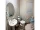 Well-appointed bathroom featuring a pedestal sink, oval mirror, and elegant decor creates a charming space at 5126 Buckwheat Rd, Brighton, CO 80640