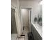 Bathroom features tiled shower, grey vanity, and an open doorway to an adjoining space at 5126 Buckwheat Rd, Brighton, CO 80640