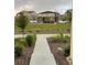 View of a landscaped front yard, complete with manicured lawn, pathway, and neighboring houses at 5126 Buckwheat Rd, Brighton, CO 80640