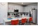 Bright kitchen with a quartz island, gray cabinets, stainless steel appliances, and open layout at 5126 Buckwheat Rd, Brighton, CO 80640