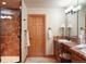 Elegant bathroom featuring dual sinks, a spacious shower, and warm lighting that creates a welcoming atmosphere at 20050 Lost Arrowhead Dr, Monument, CO 80132