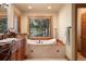 Well-lit bathroom features a soaking tub, and a large window with a scenic view and bright natural light at 20050 Lost Arrowhead Dr, Monument, CO 80132