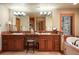 Elegant bathroom featuring dual sinks, warm wood cabinets and a large mirror with great lighting at 20050 Lost Arrowhead Dr, Monument, CO 80132