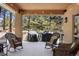Relaxing covered deck featuring comfortable seating and views of the surrounding trees at 20050 Lost Arrowhead Dr, Monument, CO 80132