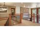 Spacious hallway featuring railing, carpeted floor and a stone accent wall that adds a touch of elegance at 20050 Lost Arrowhead Dr, Monument, CO 80132