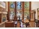 Bright living room with a stone fireplace, large windows, and hardwood floors at 20050 Lost Arrowhead Dr, Monument, CO 80132