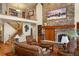 Cozy living room featuring a stone fireplace, hardwood floors, and comfortable seating at 20050 Lost Arrowhead Dr, Monument, CO 80132