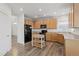 Well-lit kitchen featuring wood cabinets, black appliances, and wood floors at 134 Laramie Ct, Castle Rock, CO 80104