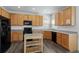 Well-lit kitchen features wood cabinets, black appliances, and wood floors at 134 Laramie Ct, Castle Rock, CO 80104