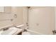 Bathroom with white tiled shower and tub, vanity with sink, and glass shelving at 7661 Gray Way, Arvada, CO 80003