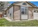 Charming single-Gathering home boasts a manicured lawn, brick accents, and an attached garage at 7661 Gray Way, Arvada, CO 80003