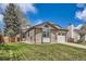 Charming single-Gathering home boasts a manicured lawn, brick accents, and an attached garage at 7661 Gray Way, Arvada, CO 80003