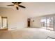Bright living room features vaulted ceilings, neutral carpet, and sliding door access to a deck at 7661 Gray Way, Arvada, CO 80003