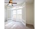 Bedroom featuring carpet, ceiling fan, and shuttered double doors to the outside balcony at 1950 N Logan St # 102, Denver, CO 80203