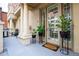 Elegant building entrance featuring stately columns and potted plants adorning the doorway and a grill on the deck at 1950 N Logan St # 102, Denver, CO 80203