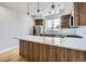 Modern kitchen featuring custom wood cabinets, white countertops, pendant lighting and stainless steel appliances at 3520 W Conejos Pl # 11, Denver, CO 80204