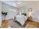 Bright bedroom with wood floors, white walls, two windows, and a comfortable bed with stylish decor at 50 Yarrow St, Lakewood, CO 80226