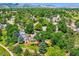 Scenic aerial shot of the home surrounded by mature trees, a red barn, and a sprawling neighborhood at 6348 S Independence St, Littleton, CO 80123
