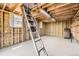 Spacious unfinished attic with exposed beams, utility ladder, and natural lighting at 6348 S Independence St, Littleton, CO 80123