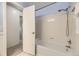Clean bathroom showcasing a white tiled shower-tub and a view of the hallway at 6348 S Independence St, Littleton, CO 80123