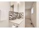 Bathroom featuring mosaic backsplash, modern fixtures, and ample storage at 6348 S Independence St, Littleton, CO 80123