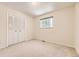 Spacious bedroom featuring a large window, plush carpet, and bi-fold closet doors at 6348 S Independence St, Littleton, CO 80123