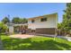 Back exterior with brick and vinyl siding, plus a small patio and grassy yard at 6348 S Independence St, Littleton, CO 80123