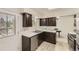 Updated kitchen featuring stainless steel appliances, neutral countertops, and dark wood cabinetry at 6348 S Independence St, Littleton, CO 80123