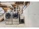 Functional laundry room with modern washer and dryer, concrete walls, and utility sink at 6348 S Independence St, Littleton, CO 80123