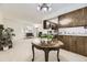 Open-concept living room featuring a brick fireplace, neutral carpet, and seamless flow into the kitchen at 6348 S Independence St, Littleton, CO 80123