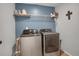 Modern laundry room features a side-by-side washer and dryer and shelving at 4391 S Nepal St, Centennial, CO 80015