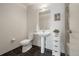 Well-lit bathroom with pedestal sink, dark tile flooring, and neutral wall color at 410 Acoma St # 314, Denver, CO 80204