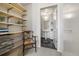 Bright walk-in closet with built in shelving, drawers, and view into a half bath at 410 Acoma St # 314, Denver, CO 80204