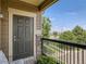 Balcony with dark door looking out to trees, a street and grassy areas at 8726 S Kline St # A208, Littleton, CO 80127