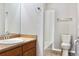 Bright bathroom featuring a single sink vanity with wood cabinets and a tub at 8726 S Kline St # A208, Littleton, CO 80127
