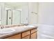 Bathroom showcasing a double sink vanity and shower with glass enclosure and bathtub at 8726 S Kline St # A208, Littleton, CO 80127