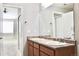 Bright bathroom featuring a double sink vanity with wood cabinets and a large mirror at 8726 S Kline St # A208, Littleton, CO 80127