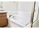 A white bathtub with white tile surround with chrome faucet and fixtures and glass door at 8726 S Kline St # A208, Littleton, CO 80127