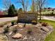 Stone sign for Chatfield Bluffs, a covenant controlled community, with manicured landscaping and a glimpse of houses at 8726 S Kline St # A208, Littleton, CO 80127