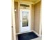 Apartment unit front door with glass inset, house number, exterior light, and welcome mat at 8726 S Kline St # A208, Littleton, CO 80127