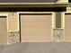 Garage with stone accents and gravel driveway at 8726 S Kline St # A208, Littleton, CO 80127