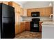 Well-equipped kitchen with black appliances, ample cabinet space, and practical countertops at 8726 S Kline St # A208, Littleton, CO 80127